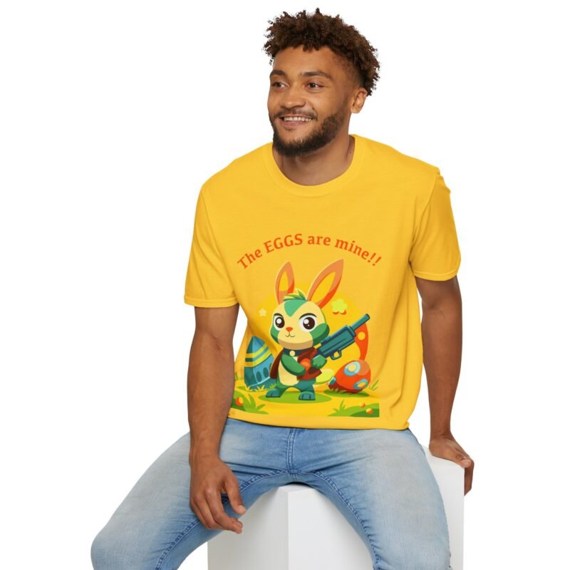a man sitting on a cube weraing a yellow t shirt with a illustrated bunny holding gun with a the The eggs are mine